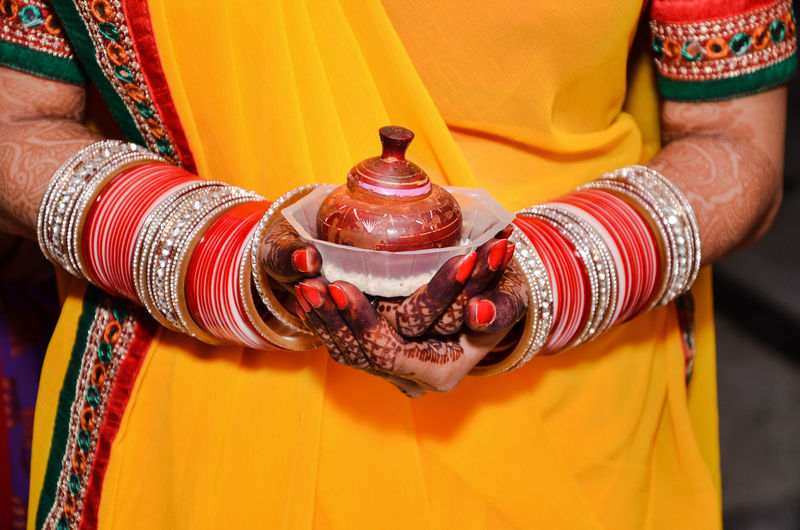An women holding a bowl of vermilion on her wedding.its a ritual of indian  traditional wedding.