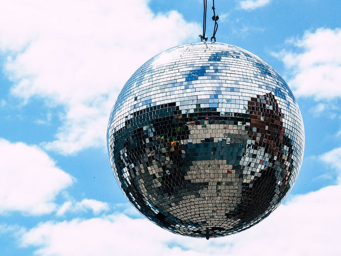 Close-up of disco ball hanging against sky