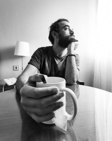 Mid adult man holding tea cup on table