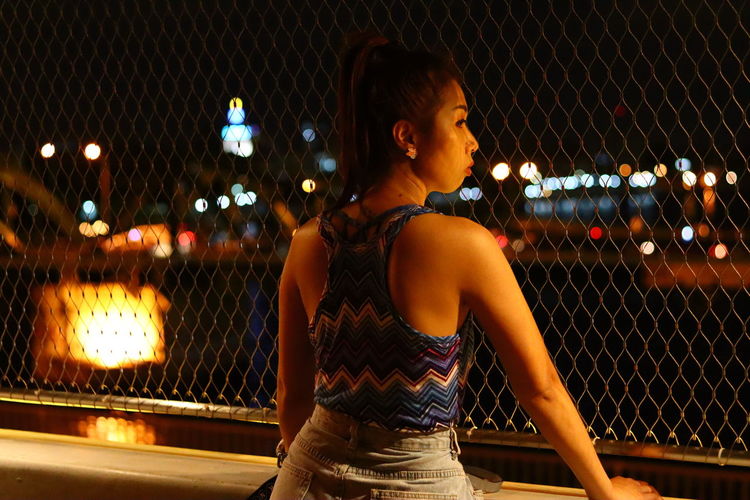 Woman looking at illuminated city at night