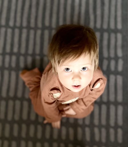 High angle portrait of smiling girl holding indoors