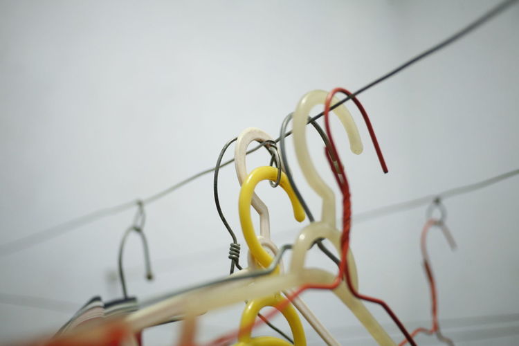 Close-up of multi colored hangers against white background