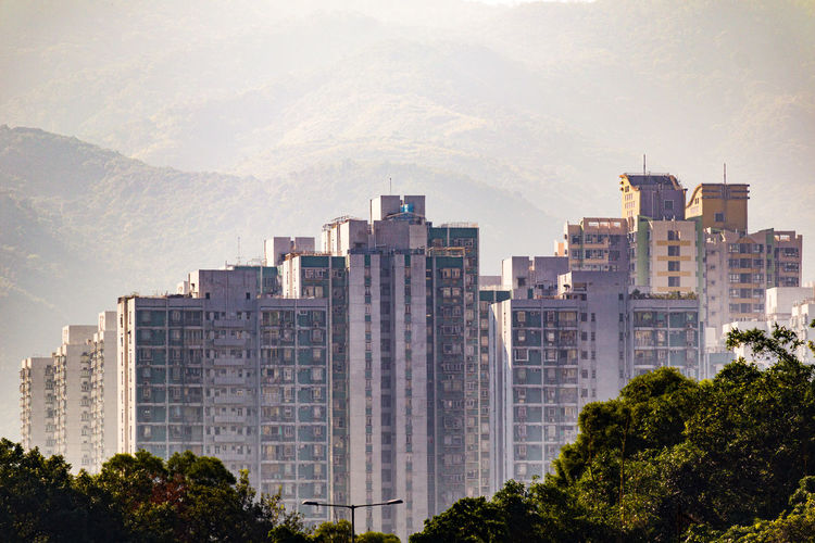 Buildings in city against mountains