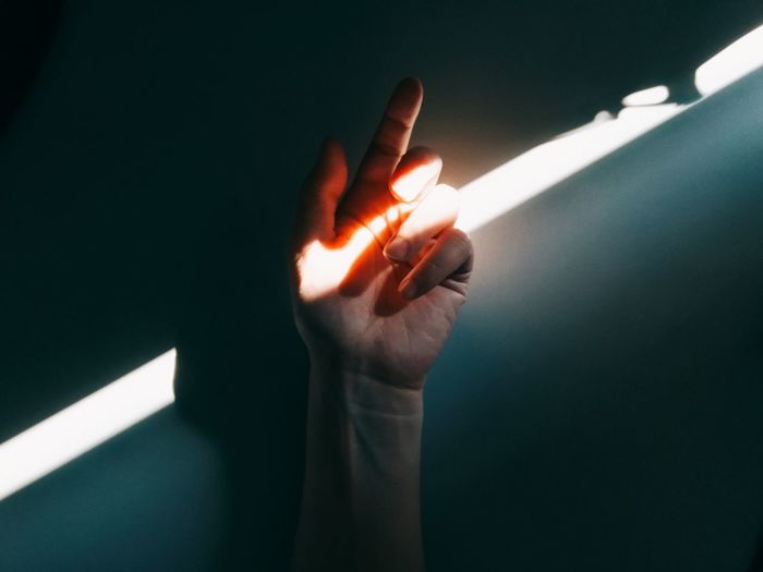 Close-up of hand touching illuminated lamp