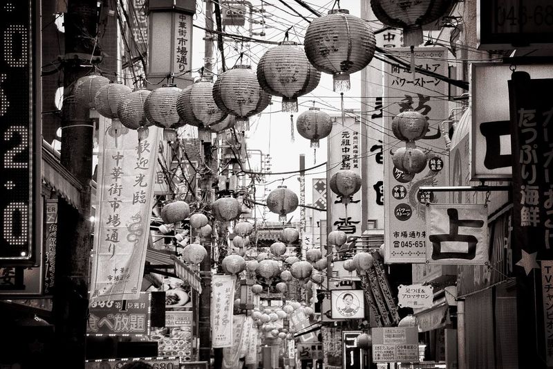Japanese lanterns over street amidst buildings
