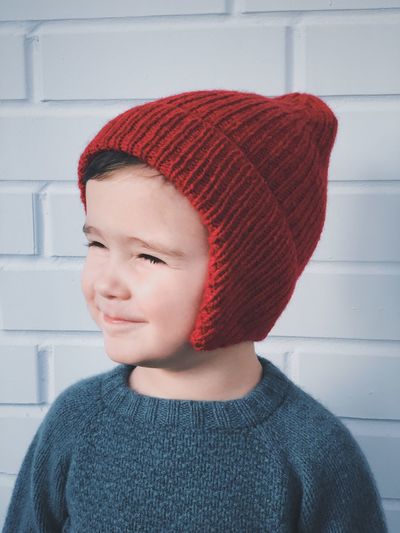 Close-up portrait of boy wearing hat against wall