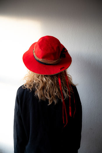 Rear view of woman wearing hat against black background