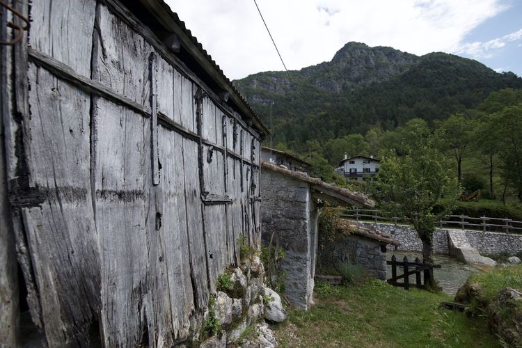 Built structure by trees and buildings against sky