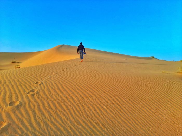 Walking on sand dunes on sahara desert of algeria