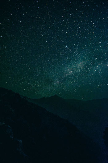 Scenic view of mountains against star field at night