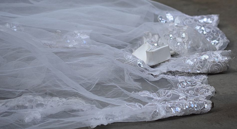 Close-up of wedding dress on floor