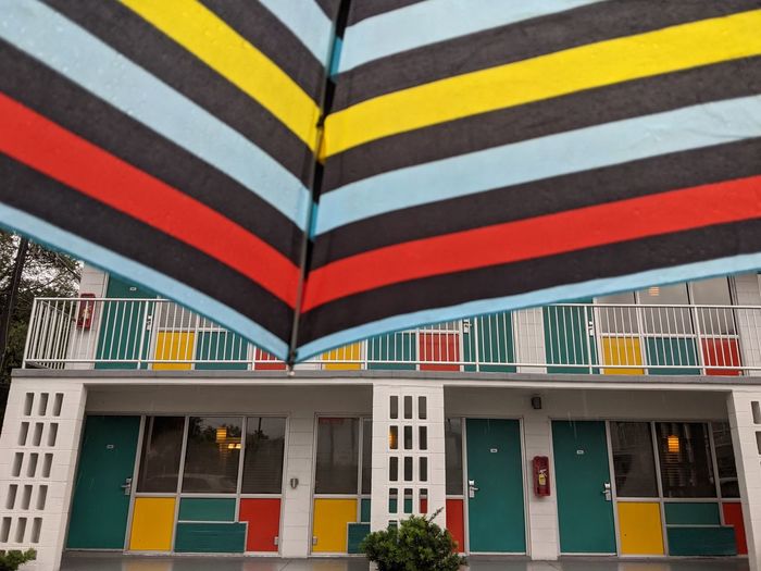 Standing under an umbrella looking at a retro-style motel 