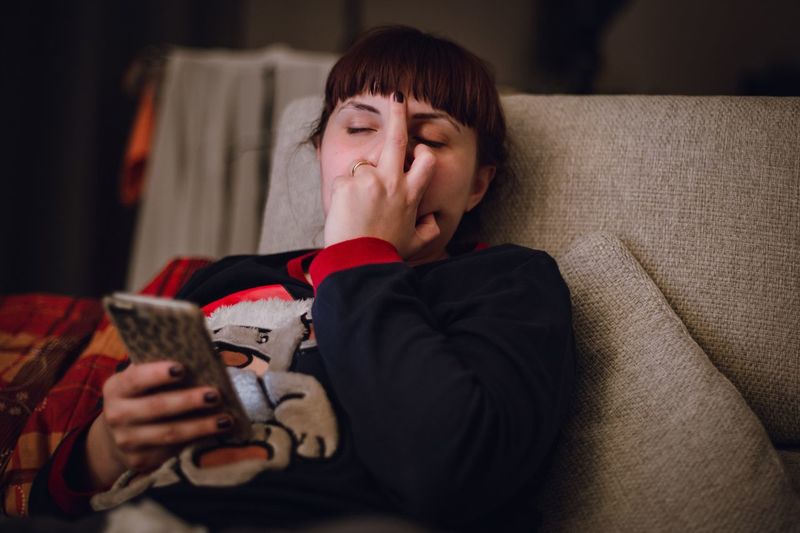 Woman showing obscene gesture at home