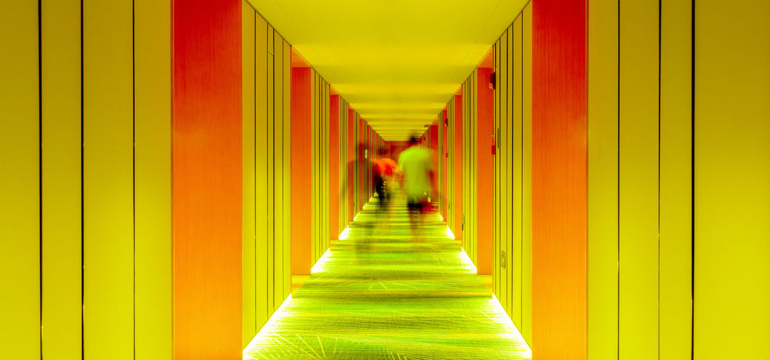 Rear view of people walking in corridor of building