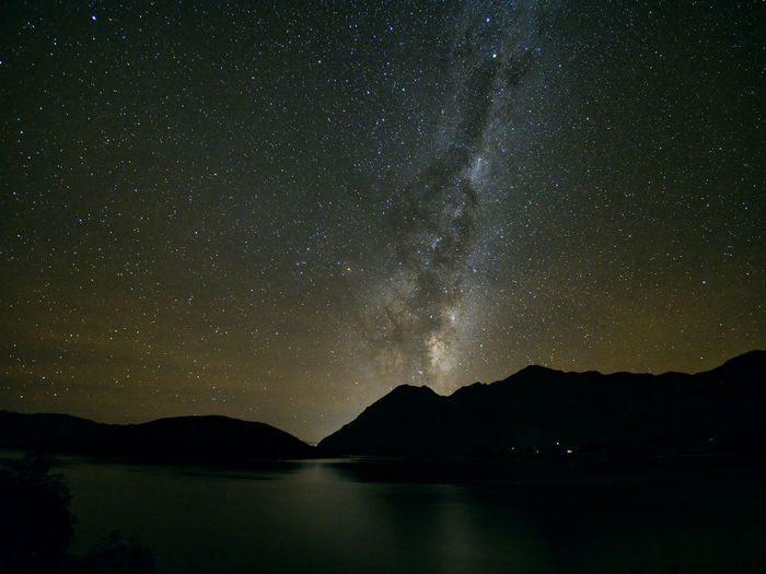 Scenic view of lake against mountains at night
