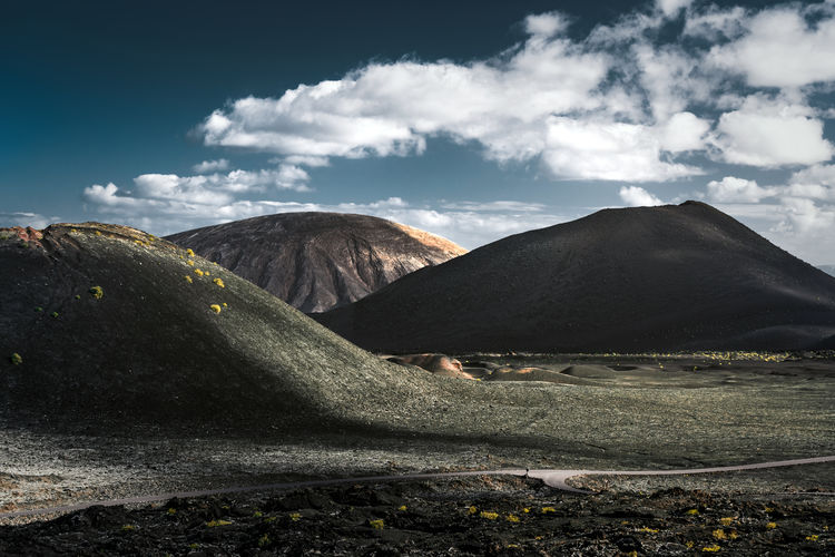 Scenic view of volcanic craters against cloudy sky