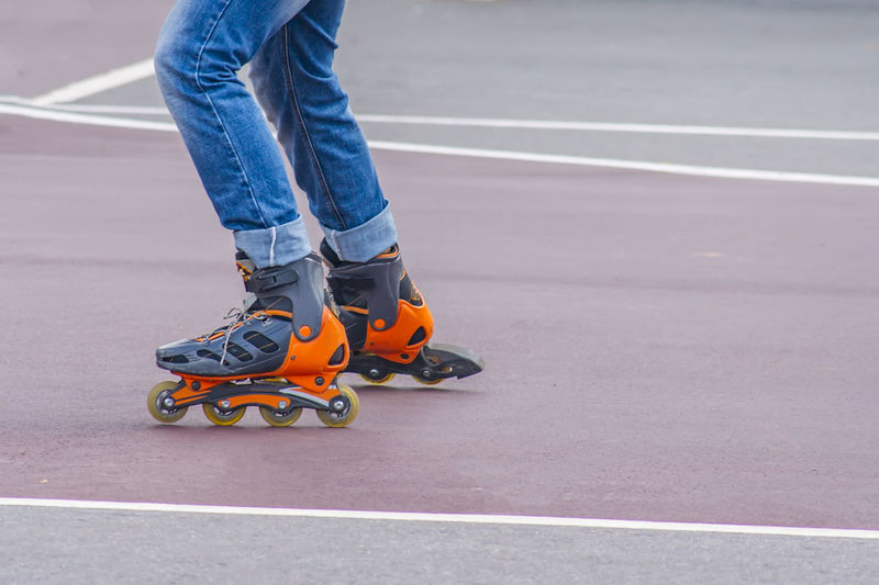 Low section of man roller skating on road
