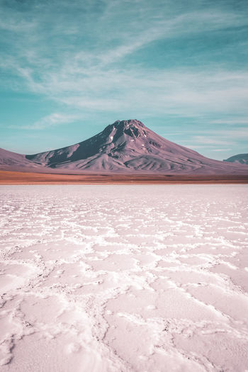 Scenic view of salt flat in front of volcano in atacama desert