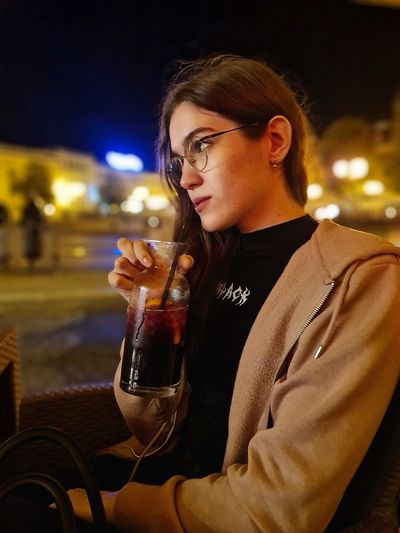 Young woman drinking at night