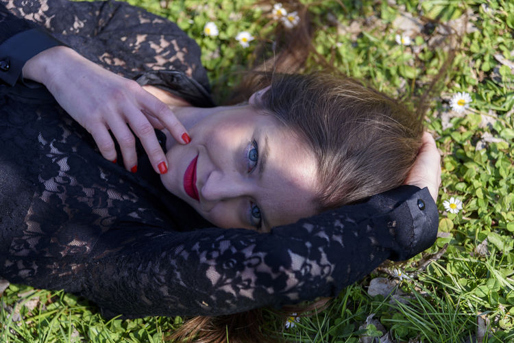 High angle portrait of woman lying on field