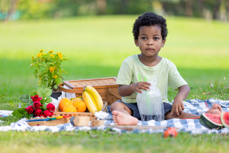 Portrait of cute boy eating food at park