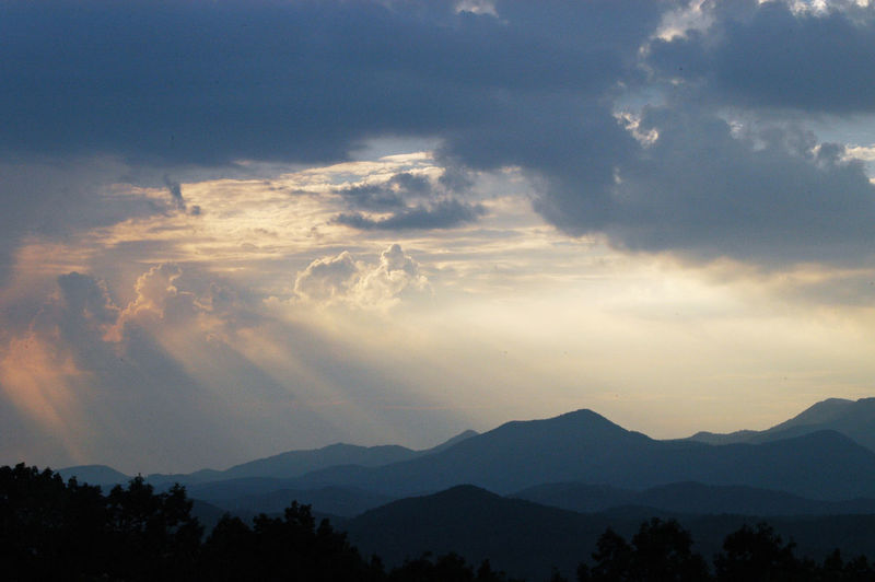 Scenic view of silhouetted mountains against sky at sunset