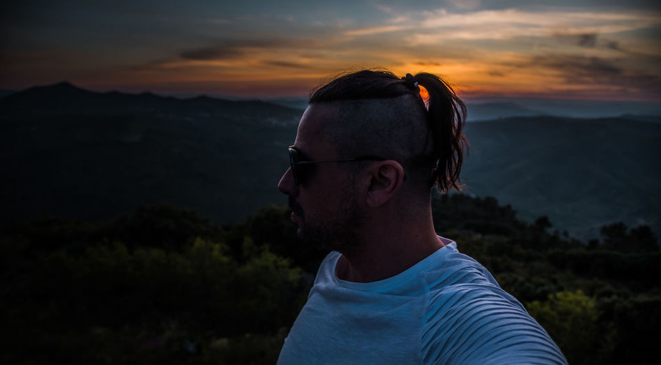 Portrait of mature man against mountains during sunset