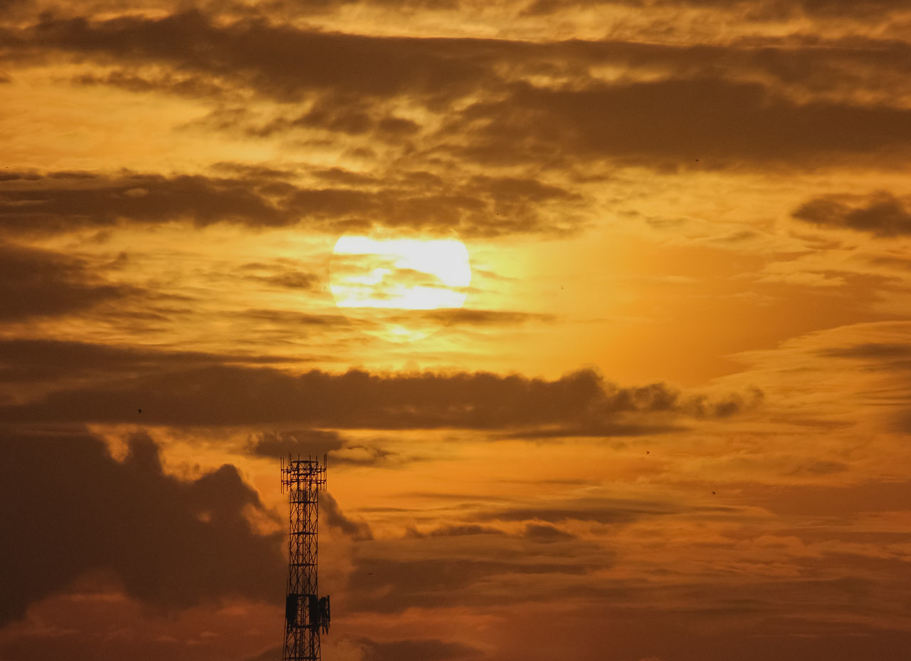 LOW ANGLE VIEW OF COMMUNICATIONS TOWER AGAINST ORANGE SKY
