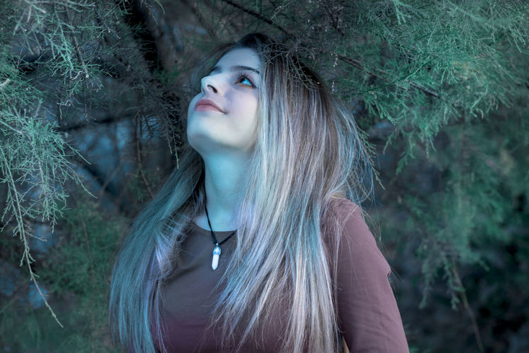 Close-up of woman looking away in forest