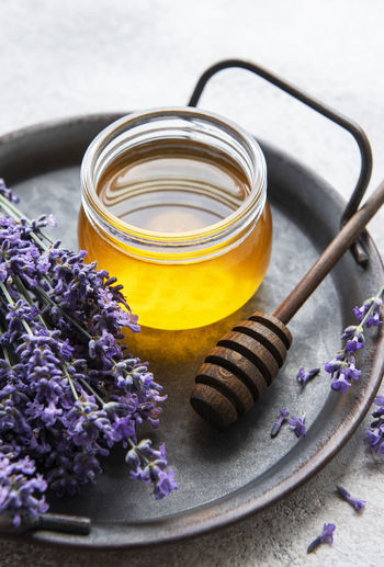 Jar with honey and fresh lavender flowers on a concrete background
