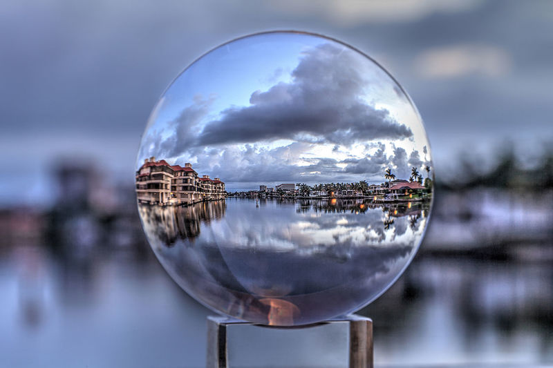 Crystal ball view of sunrise at a waterway of venetian bay in naples, florida at sunrise.