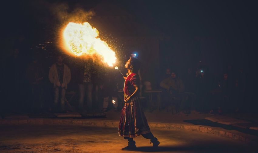 Fire-eater performing on street at night