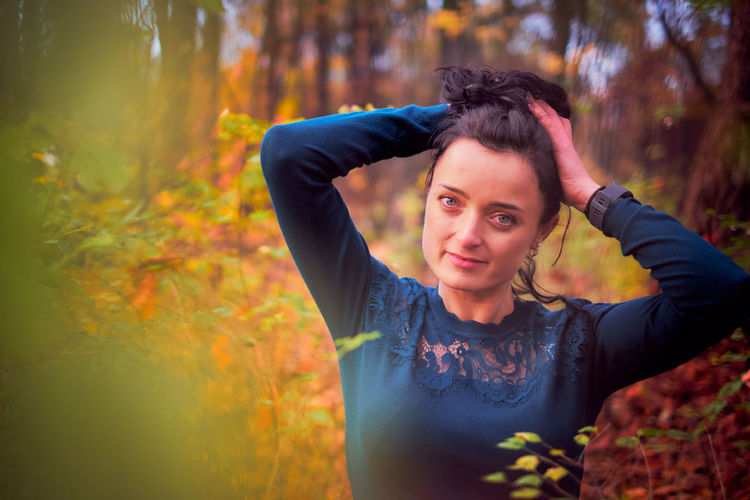 Portrait of young woman standing in forest