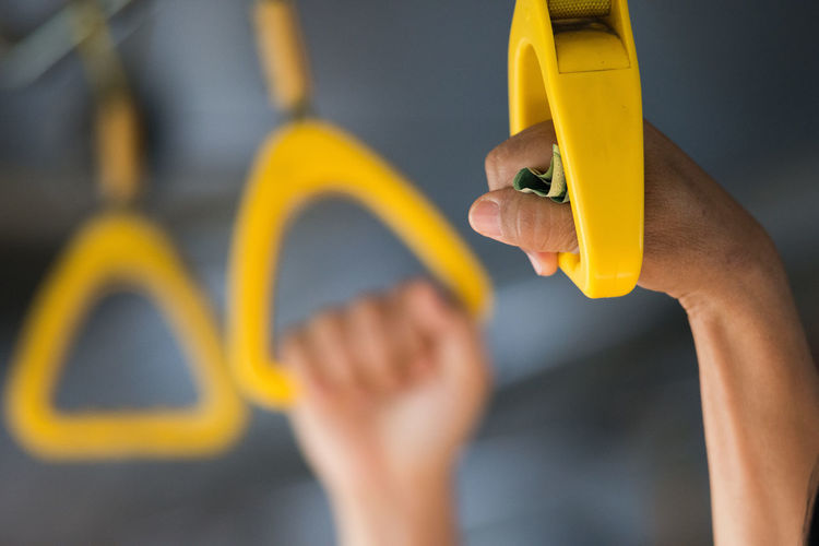 Cropped image of person holding handle in bus