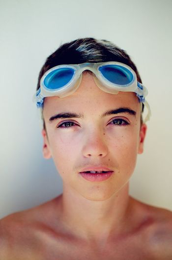 Close-up portrait of teenage boy wearing swimming goggles