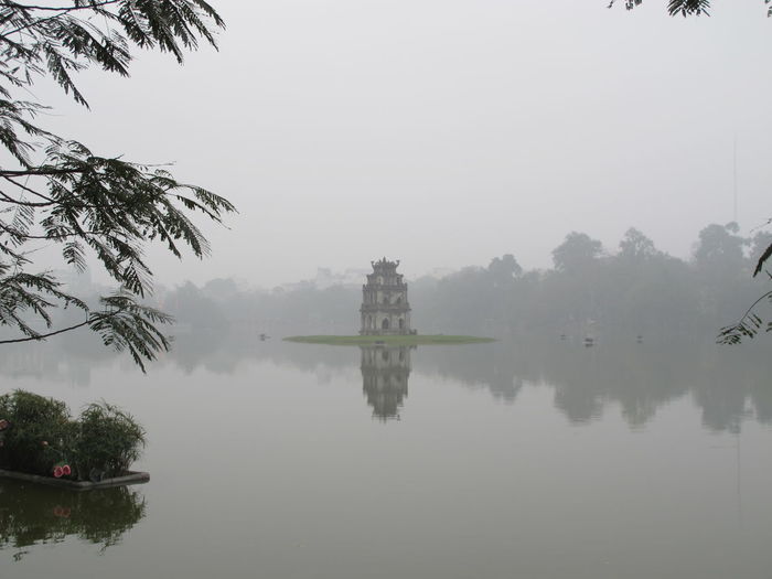 Temple in hoan kiem lake against sky during foggy weather