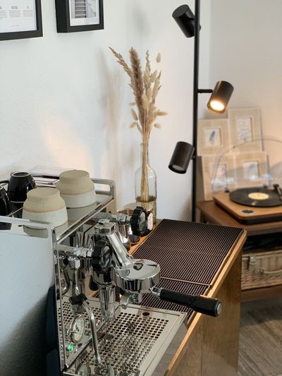 Close-up of electric lamp on table against wall at home