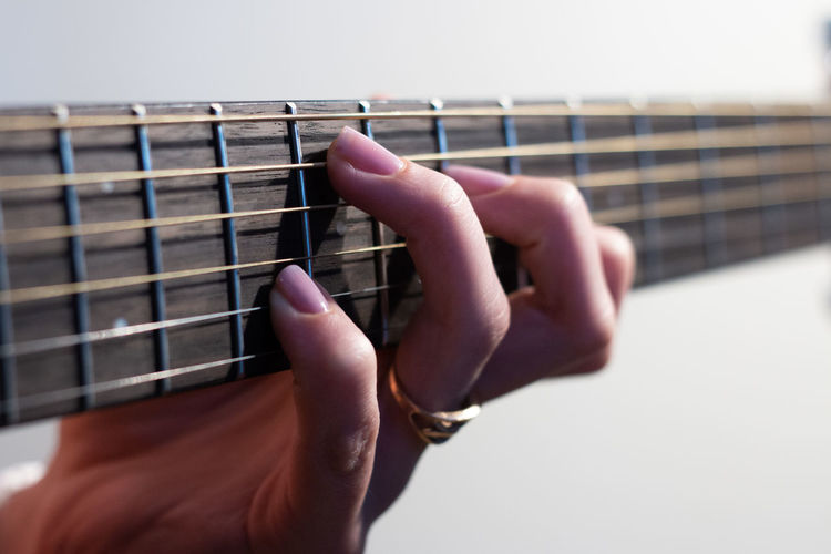 Close-up of female hand playing a western guitar