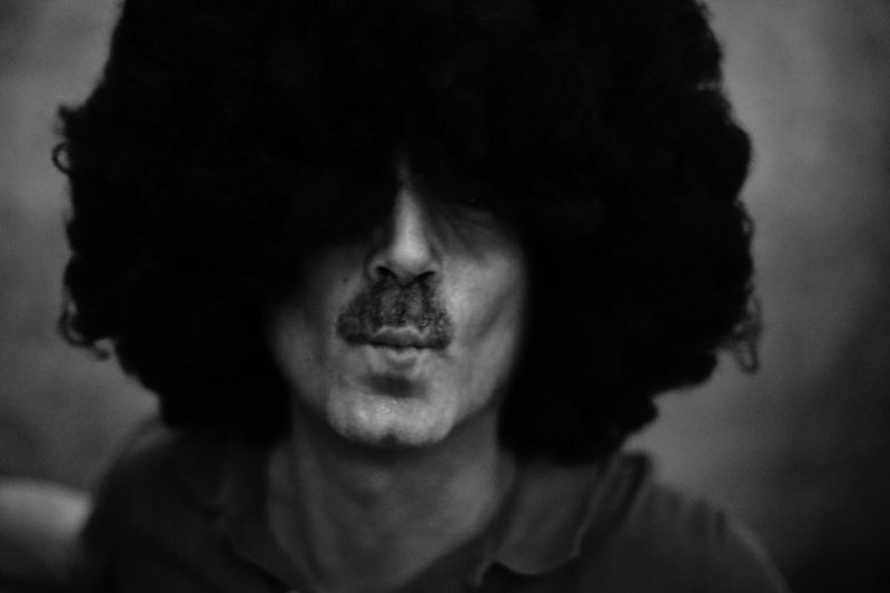 Close-up of man wearing curly wig