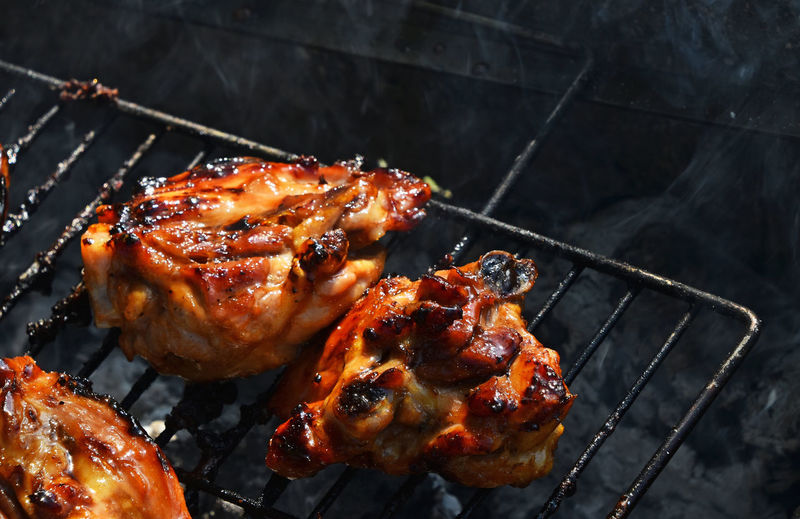 High angle view of chicken cooking on barbecue grill