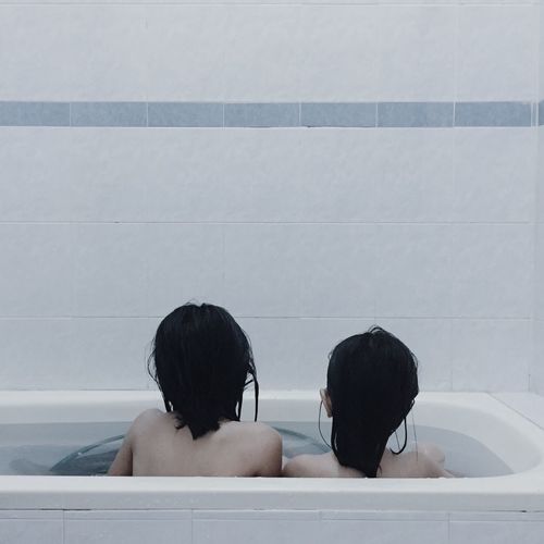 Rear view of people in bathroom