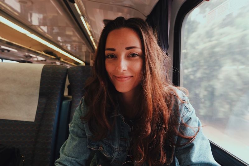 Portrait of young woman sitting in bus