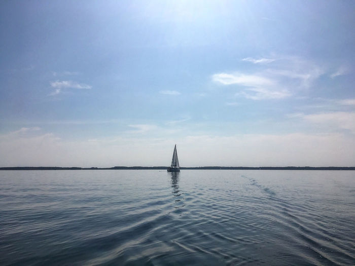 Sailboat in sea against sky
