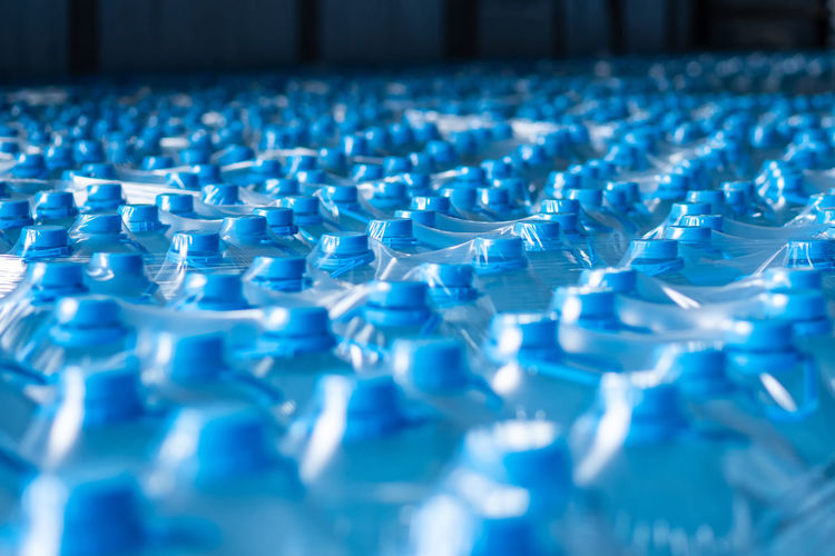 Background image of blue plastic bottles with blue cap and handle in packaging