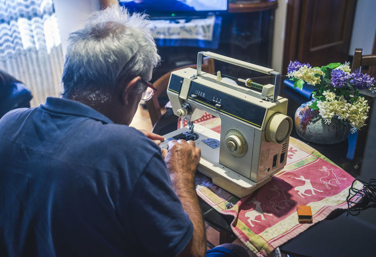 Elderly man using a sewing machine