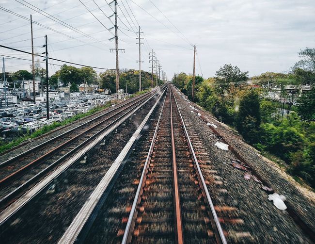 Blurred motion of railroad tracks against sky seen from wet train windshield