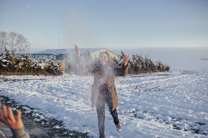 Girl throws snow in a snowy field