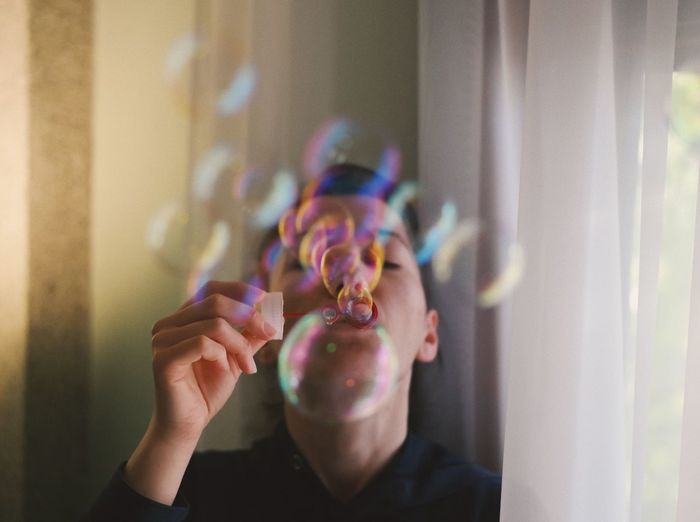 Close-up of person blowing bubbles
