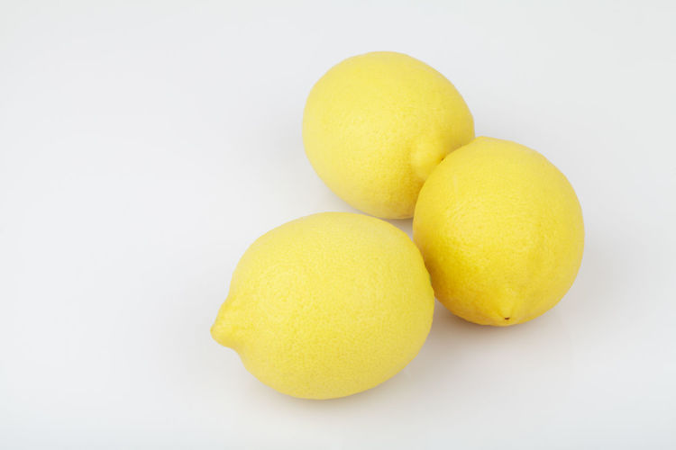 Close-up of yellow lemons over white background