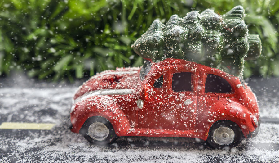 Close-up of toy car with christmas tree during snowing